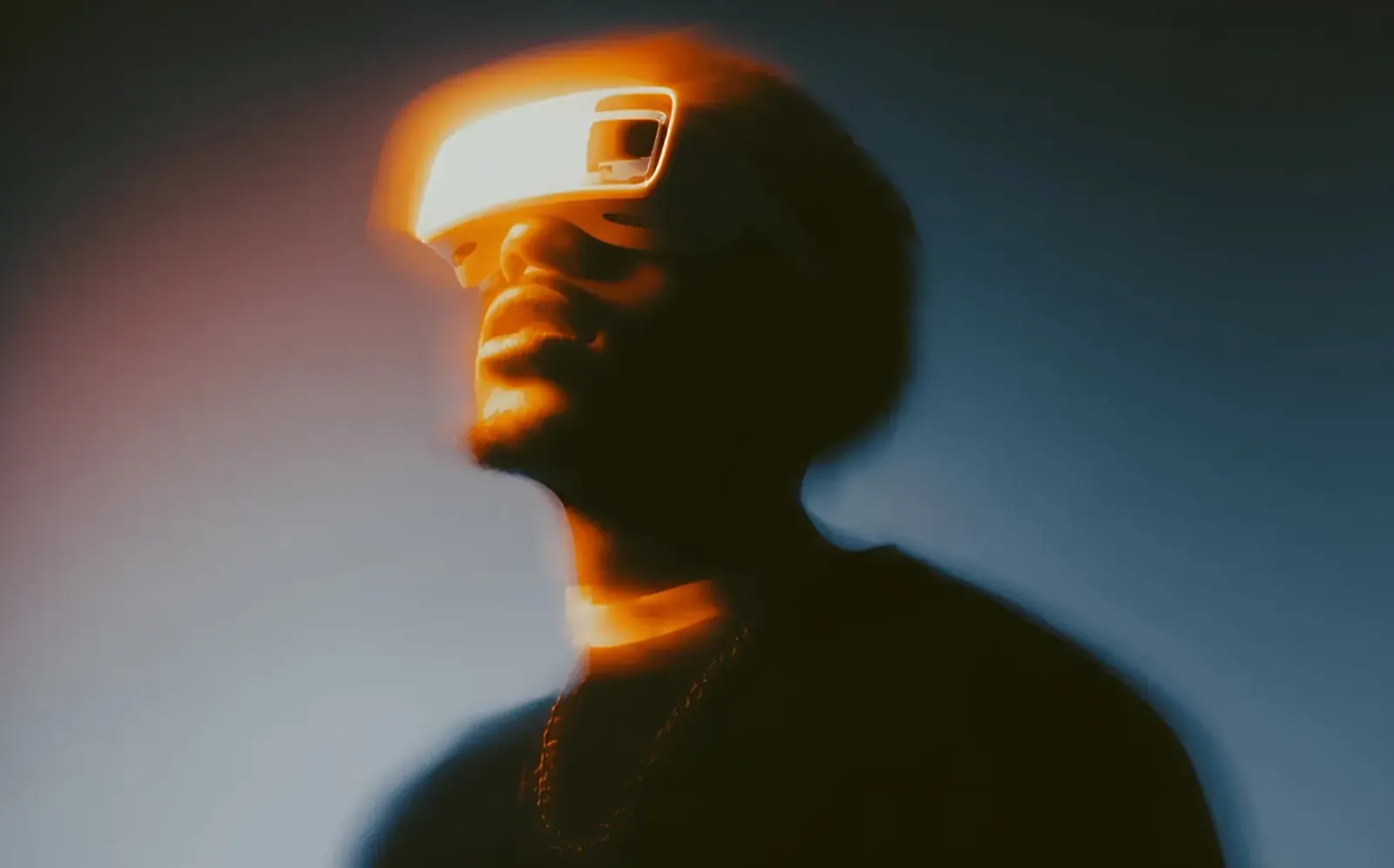 Person wearing a glowing visor in warm light