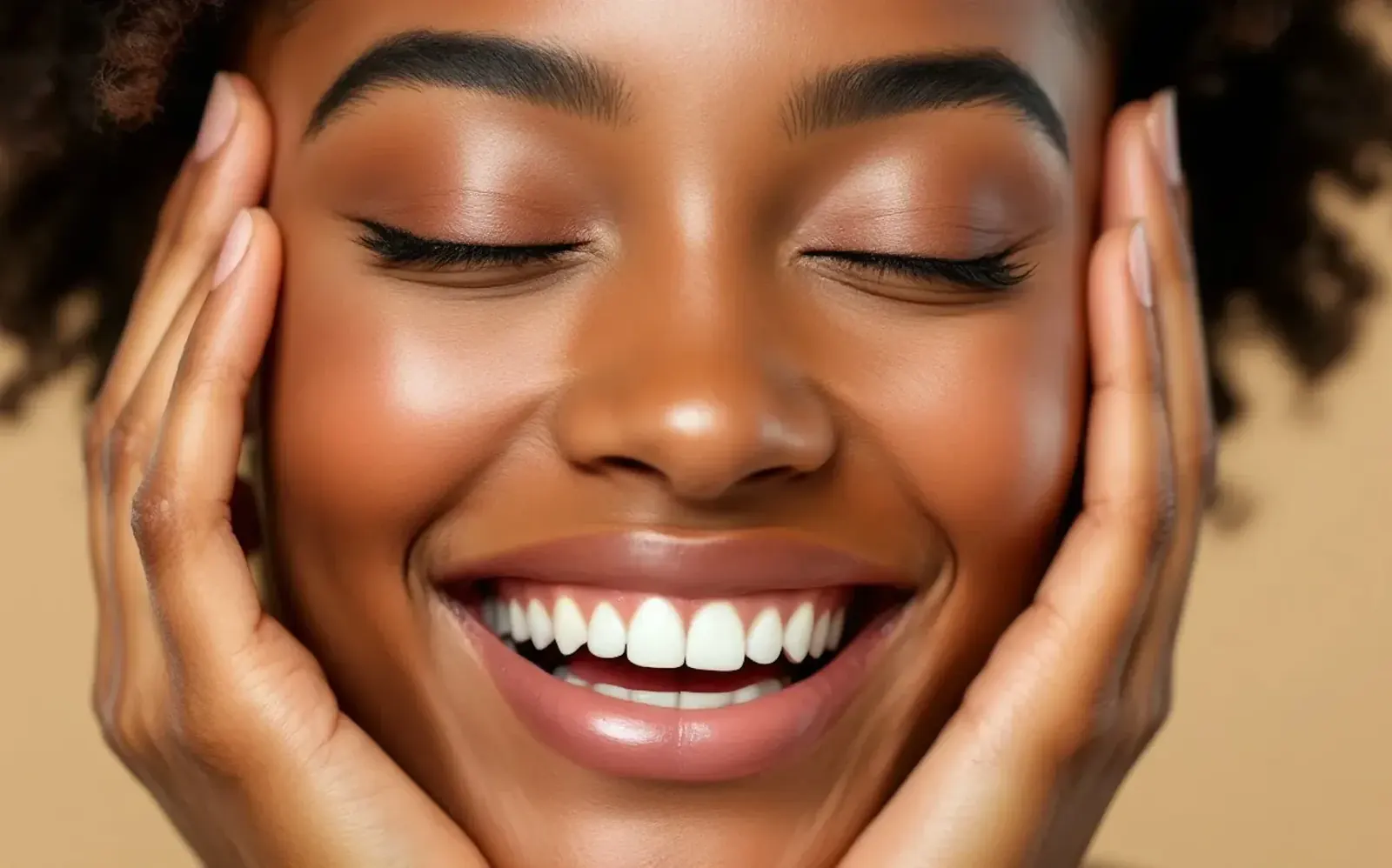 Smiling woman with her eyes closed and her hands on her face